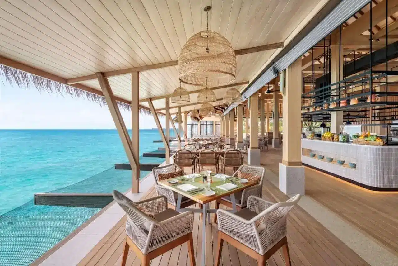 Wasservillen mit privatem Pool im Hilton Maldives Amingiri Resort & Spa bei Sonnenuntergang.