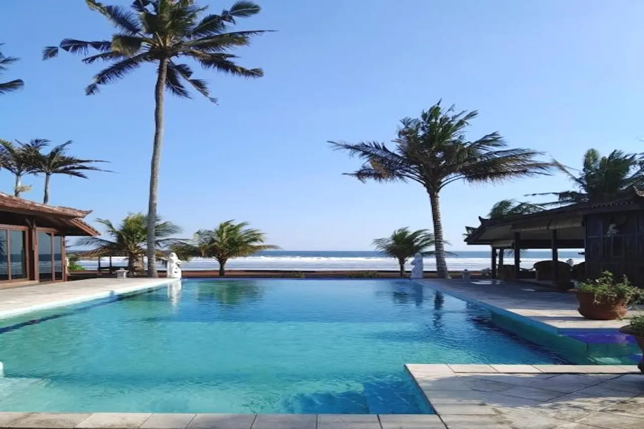 Blick auf das Bali Hai Island Resort an der Westküste Balis mit Pool, tropischer Gartenanlage und Indischem Ozean im Hintergrund.