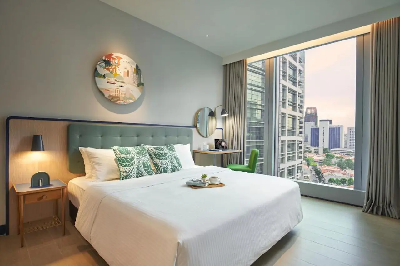 Doppelzimmer mit bodentiefem Fenster und Blick auf die Skyline. Das Citadines Raffles Place Singapore.