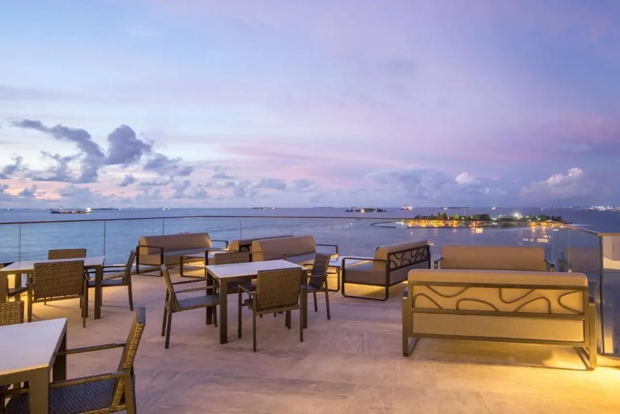 Große Terrasse des Maagiri Hotel Maldivis mit eleganten Sitzgruppen, Blick auf das Meer.