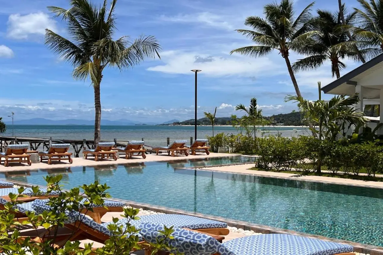 Pool mit Palmen und Meerblick im Pearl of Samui Resort.