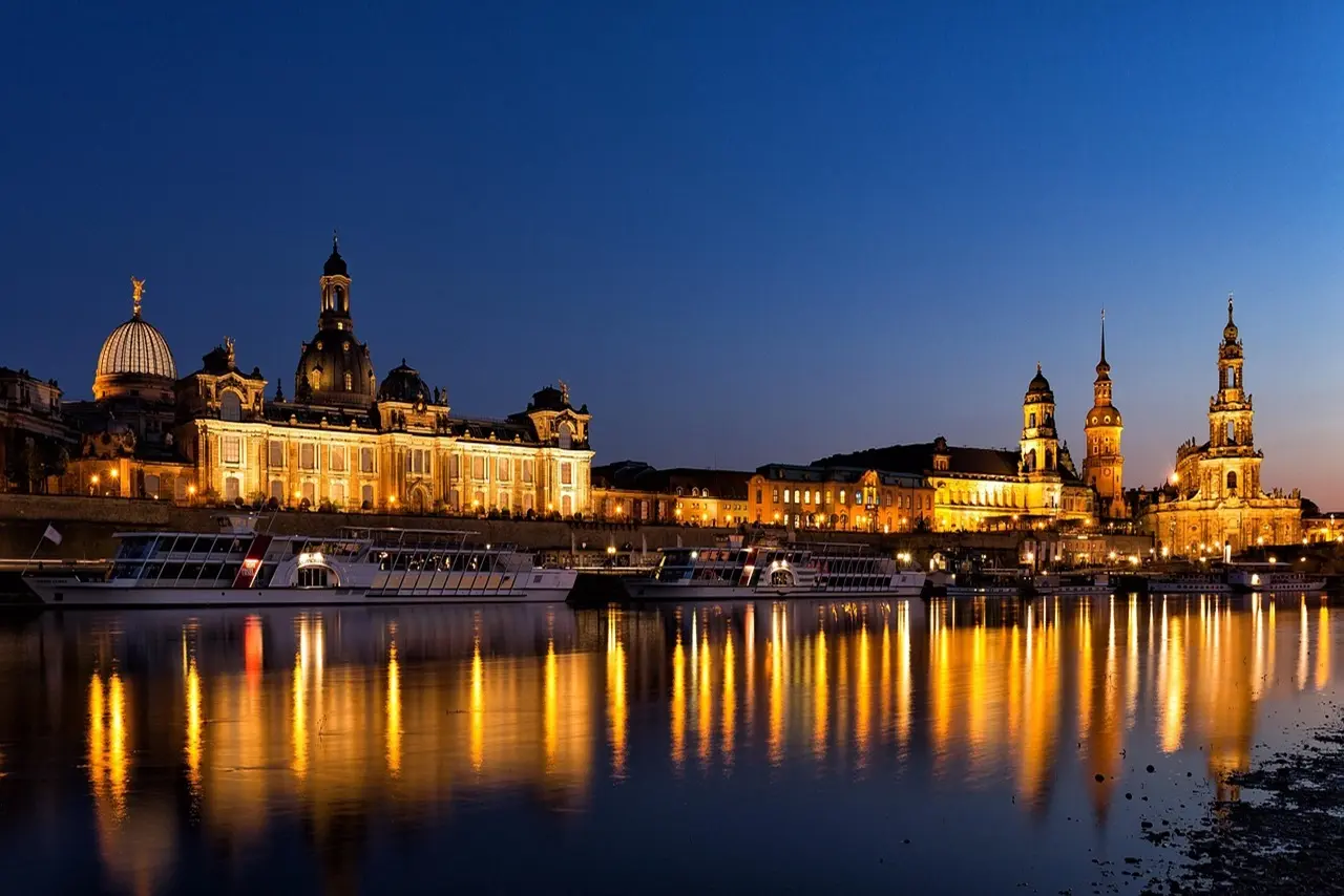Die fünf besten Hotels in Dresden – nächtliche Skyline mit Zwinger, Elbe und Ausflugsbooten.