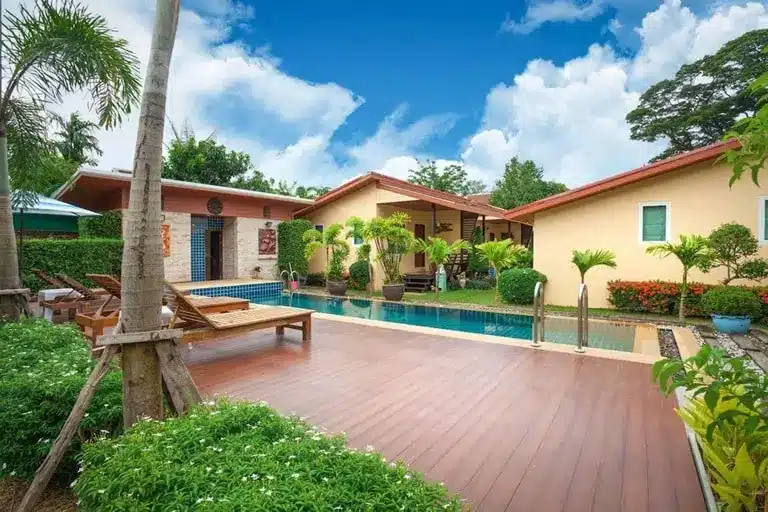 Bungalows des Siray Green Resort in tropischer Gartenanlage mit Blick auf den Pool und umliegende Vegetation auf Koh Siray bei Phuket.
