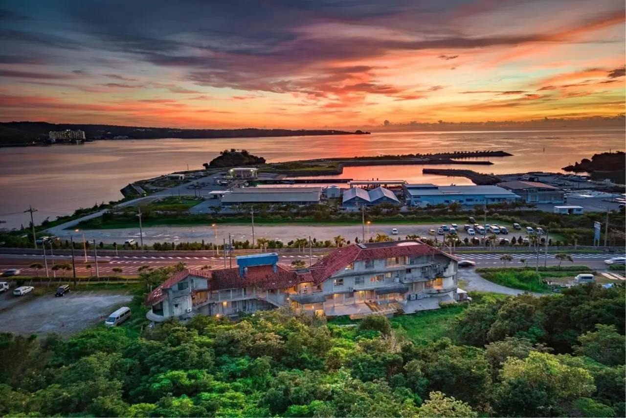 Buzz Resort Okinawa mit direkter Strandlage und Blick auf das Meer bei Sonnenuntergang.
