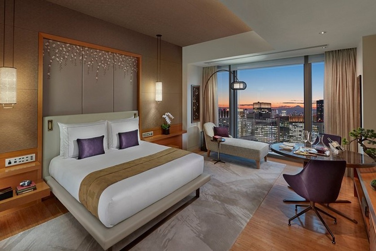 Luxuriöses Hotelzimmer im Mandarin Oriental Tokyo mit bodentiefem Panoramafenster und Blick auf die Skyline von Tokio.