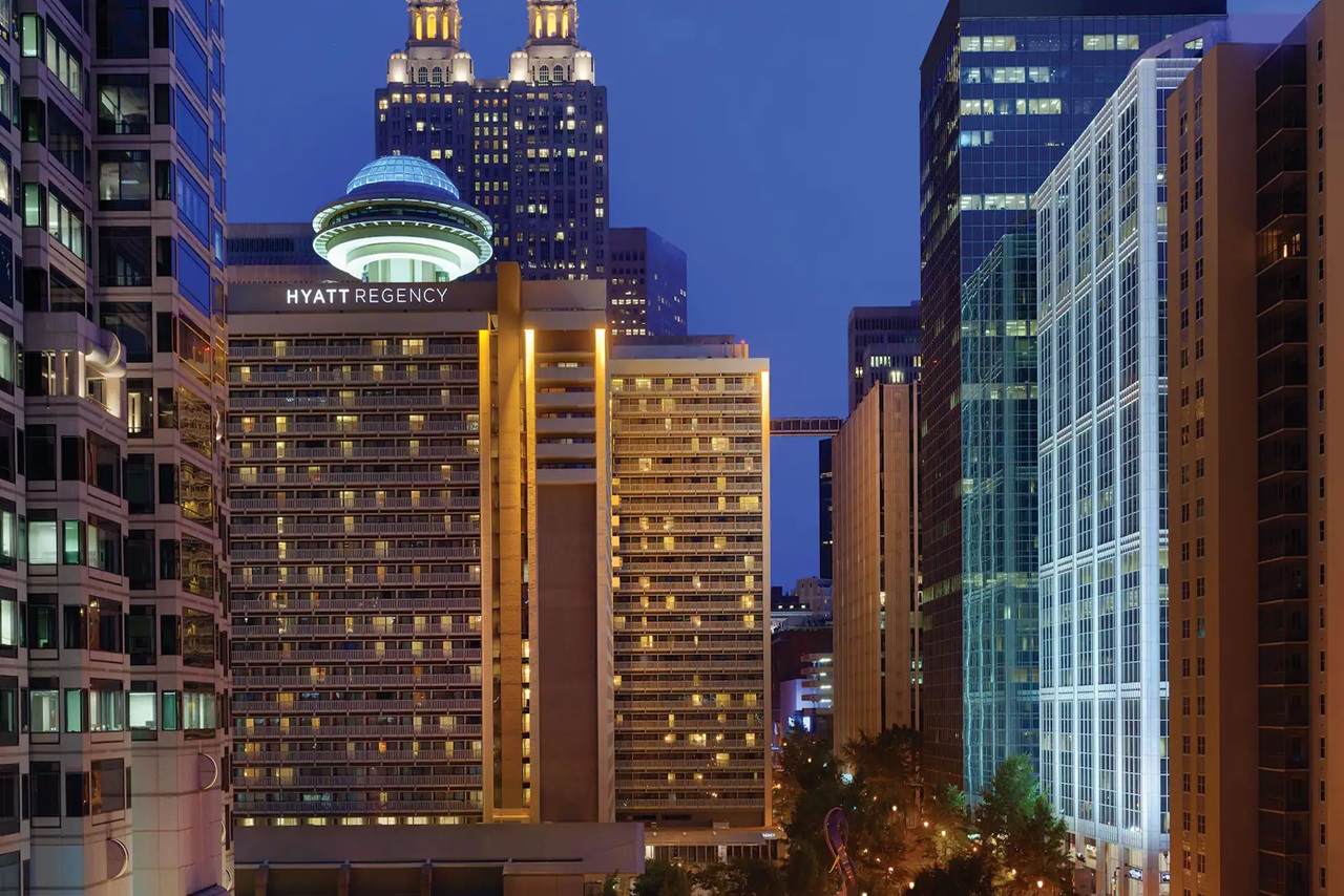 Hyatt Regency Atlanta at sunset, impressively illuminated, With a view to the city's skyline