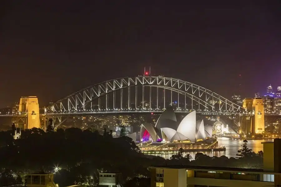 Sydney Harbour Bridge mit Sydney Opera House im Hintergrund – Macleay Hotel Sydney mit einer Nachtansicht über den Hafen