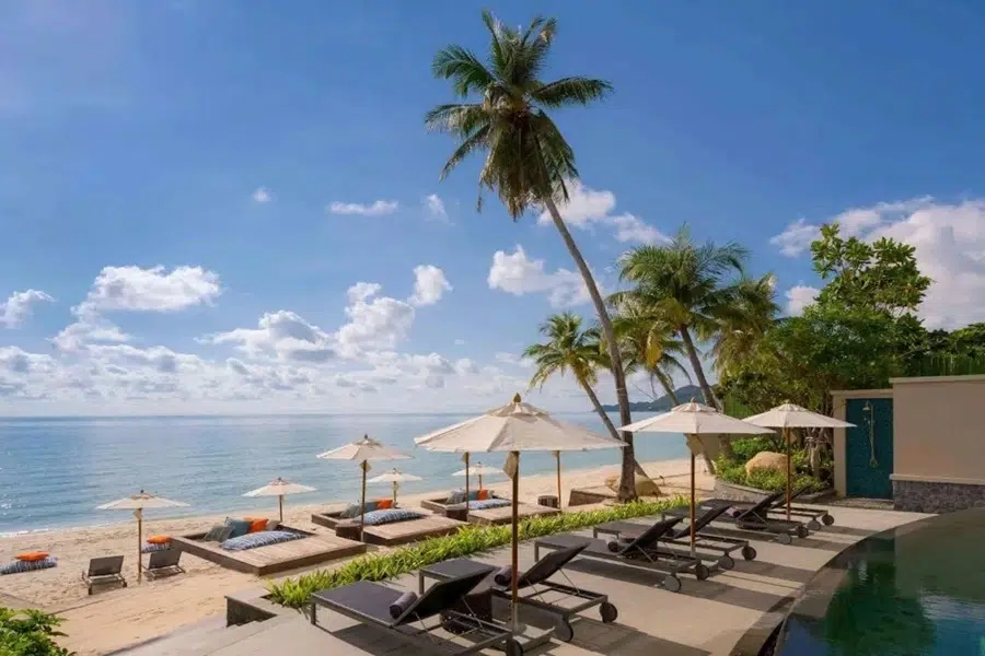 Mercure Samui Chaweng Tana – Pool mit Sonnenliegen und Schirmen, Blick auf Strand und Meer am Chaweng Beach