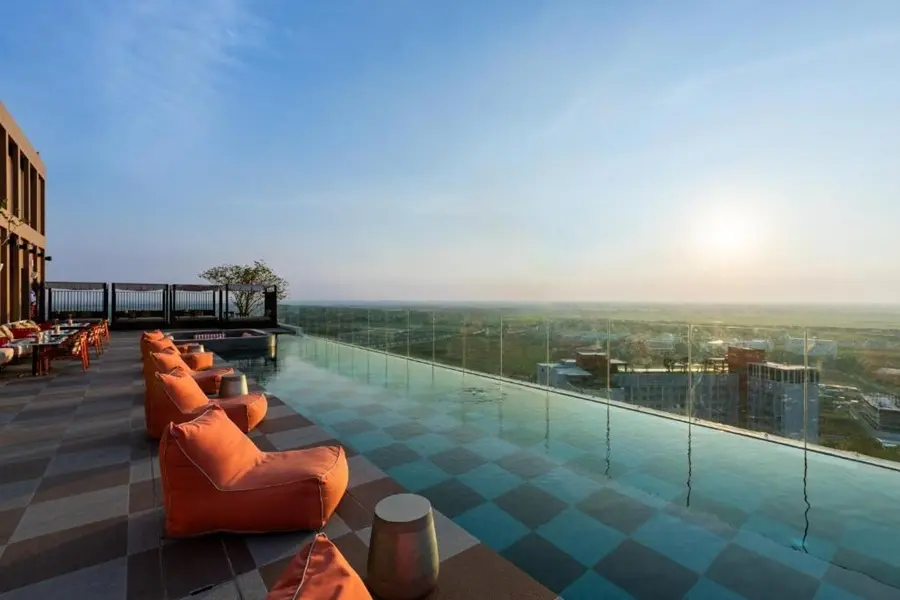 Rooftop-Pool des Centara Ayutthaya mit eleganten Liegen, Sesseln und Ausblick über die Stadt