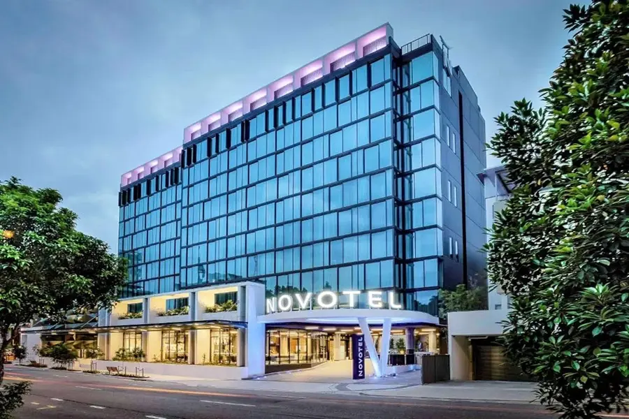 Novotel Brisbane South Bank mit Glasfassade und Bäumen im Vordergrund